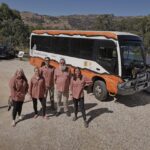 wawa biik team standing in front of bus